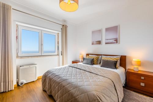 a bedroom with a bed and a large window at Ericeira Vista Mar Peace and Sea in Ericeira