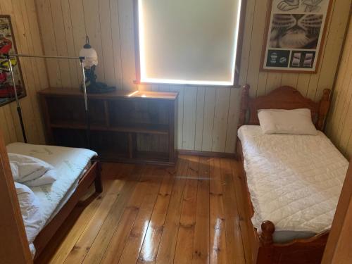 una piccola camera con due letti e una finestra di Blue Sapphire Village 3 Bedroom a Glen Innes