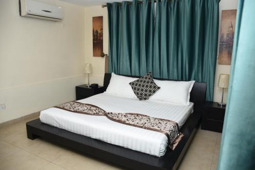 a bedroom with a bed with a green curtain at Lijam Apartments in Amman