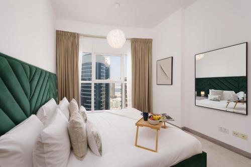 um quarto com uma cama grande e uma janela grande em Maison Privee - Elegant & Panoramic Sea View Apt on Al Reem Island em Abu Dhabi