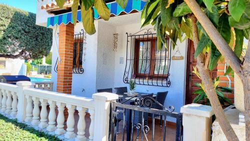 a blue house with a white fence and a porch at La Casita Denia, charming 2BR Townhouse with shared Pool, 1km to Beach in Els Poblets