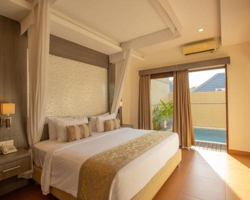 a bedroom with a large bed and a large window at Luxotic Private Villa and Resort in Nusa Dua