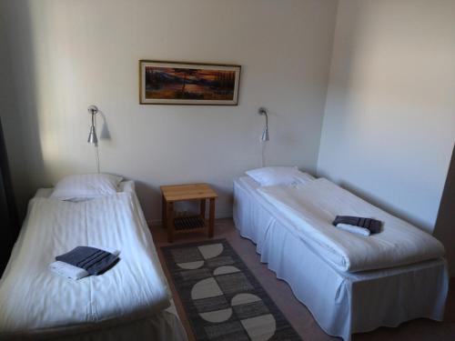 a room with two beds and a table at Hotell Hemgården in Bengtsfors