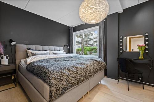 um quarto com uma cama grande e uma janela em Nydelig leilighet med privat terrasse mot bakgård em Oslo