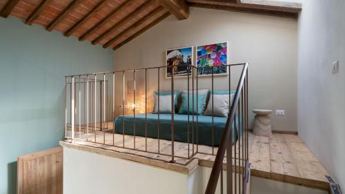 Cama de metal en una habitación con escalera en CASOLARE SAN MARTINO 16&1, Emma Villas, en Pomarance