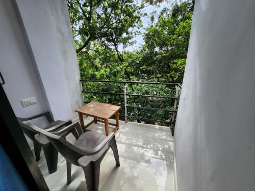 - un balcon avec une table, des chaises et des arbres dans l'établissement The Coastline Stays, à Arambol