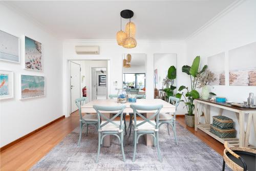 a dining room and living room with a table and chairs at Fernanda`s hideaway in Olhão