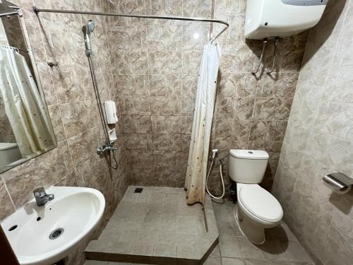 a bathroom with a shower and a toilet and a sink at Galeri Ciumbuleuit Apartment 1 2BR 1BA - code 26A in Bandung