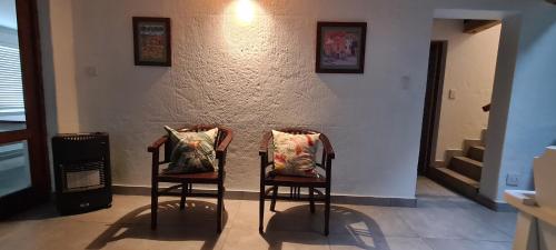 two chairs with pillows sitting next to a wall at Serenity Jacobsbay in Jacobs Bay