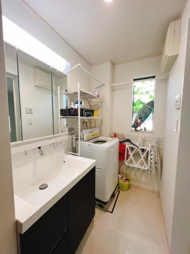 a kitchen with a sink and a washer and dryer at JINGHOUSE高砂（無料駐車場）一戸建て 上野/浅草/银座/天空树 in Tokyo