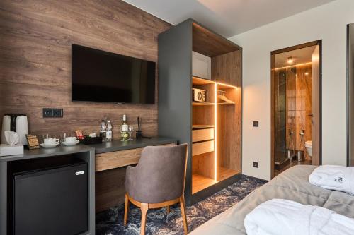 a bedroom with a bed and a desk with a television at Fomich Residence in Bukovel