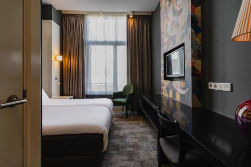 um quarto de hotel com duas camas e uma janela em Hotel JL No76 em Amesterdão