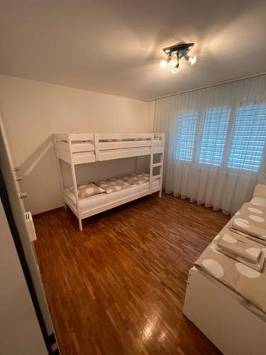 ein weißes Zimmer mit einem Bett und einem Holzboden in der Unterkunft Centered Apartment with view in Altdorf