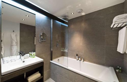 a bathroom with a tub and a sink and a shower at Moulin de Vernègues Hôtel & Spa in Mallemort