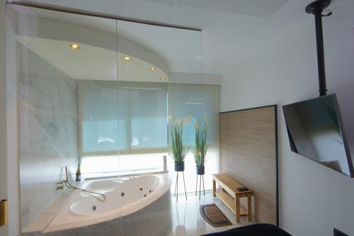 baño grande con bañera y ventana en סוויטות נוף קיסר קיסריה en Caesarea