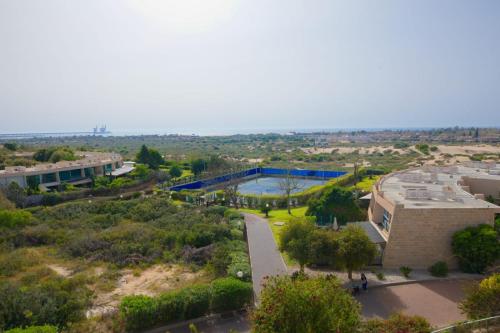 uma vista aérea de um campus com um edifício e uma piscina em סוויטות נוף קיסר קיסריה em Cesareia