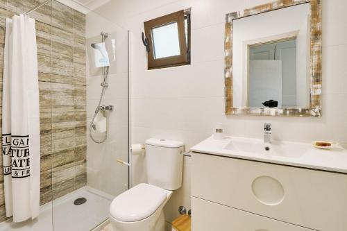 uma casa de banho com um WC, um lavatório e um espelho. em Casa da Praia mit Poolanlage em Porches