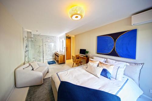 - une chambre avec un lit king-size et une chaise dans l'établissement La Promenade du Port - Balcon vue sur le port, à Barneville-Carteret