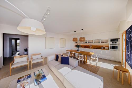 un salon et une cuisine avec un canapé et une table dans l'établissement La Promenade du Port - Balcon vue sur le port, à Barneville-Carteret