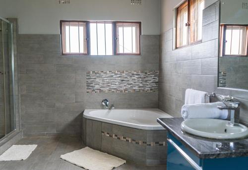 a bathroom with a tub and a sink at Malabi Exclusive Lodges in Lilongwe