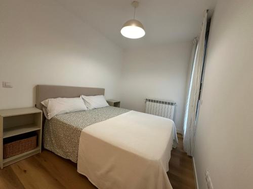 a small bedroom with a bed and a lamp at Las Margas Mirador del Valle in Huesca