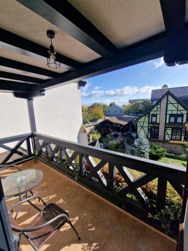 a balcony with a table and chairs and a view at Podu' cu Lanturi in Bacău