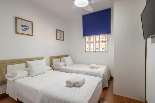 Cette chambre comprend 2 lits et une fenêtre. dans l'établissement Villa Torres Motril, à Motril