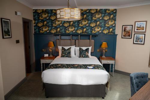 a bedroom with a large bed with a blue wall at Ethorpe Hotel by Chef & Brewer Collection in Gerrards Cross