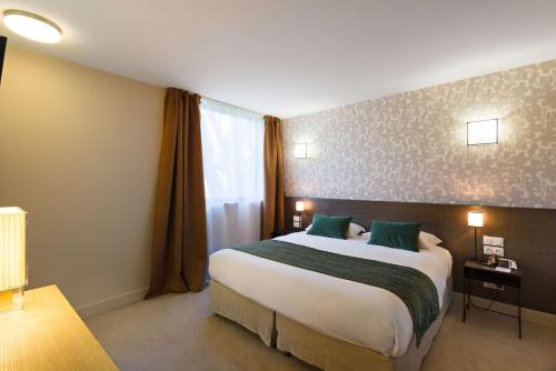 a hotel room with a large bed and a window at Moulin de Vernègues Hôtel & Spa in Mallemort