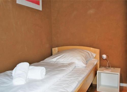 uma cama com lençóis brancos e almofadas num quarto em Haus Santalla Whg. Unterdeck em Cuxhaven