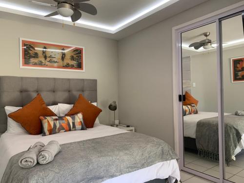 a bedroom with a bed and a mirror at Footprints Self Catering Solar No Loadshedding in Lanseria