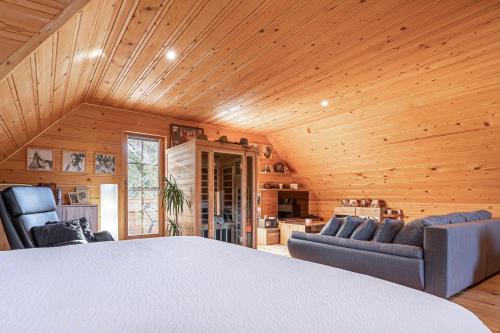 ポッチェトルテクにあるLog Cabin Chalets with Private Saunaのベッド1台、椅子2脚、キッチンが備わるアパートメントです。