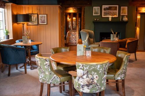 comedor con mesa de madera y sillas en Ethorpe Hotel by Chef & Brewer Collection, en Gerrards Cross