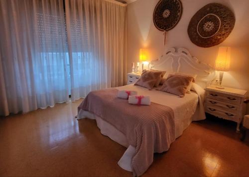 a bedroom with a white bed with two candles on it at Olimphya in Ourense