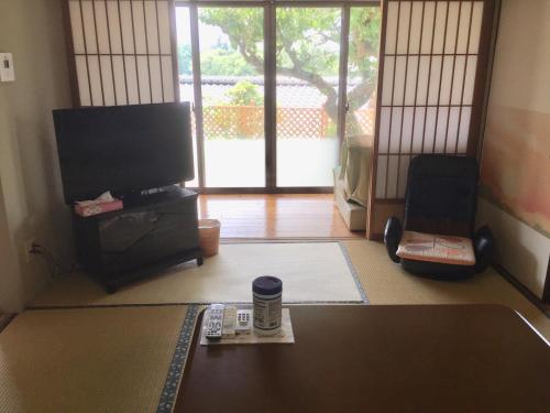 天ゆふ(Ten Yufu) في يوفو: غرفة معيشة مع تلفزيون وطاولة مع ريموت كنترول