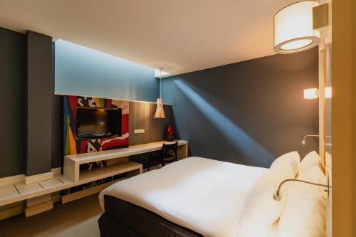 a hotel room with a bed and a tv at Hotel JL No76 in Amsterdam