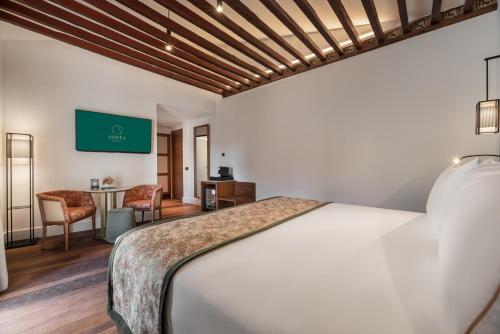 a bedroom with a bed and a desk and a tv at Áurea Toledo by Eurostars Hotel company in Toledo