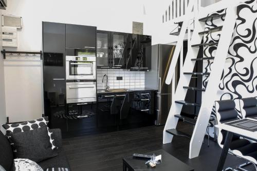 a kitchen with black and white cabinets and a staircase at Dragsö Camping & Stugby in Karlskrona