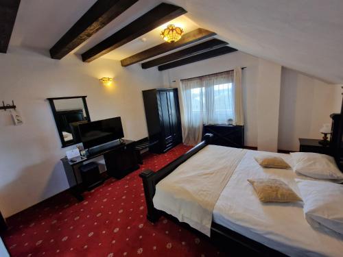 a bedroom with a large bed and a television at Podu' cu Lanturi in Bacău