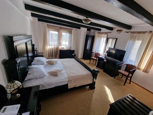a bedroom with a large bed and a desk at Podu' cu Lanturi in Bacău