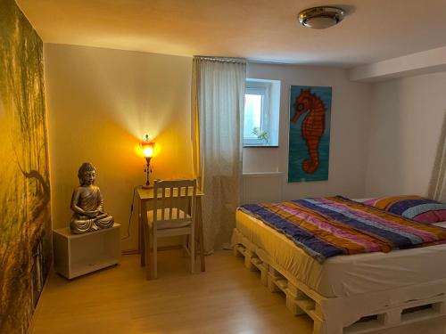 1 dormitorio con 1 cama, 1 mesa y 1 estatua en Shrinath Yog Temple en Langenfeld