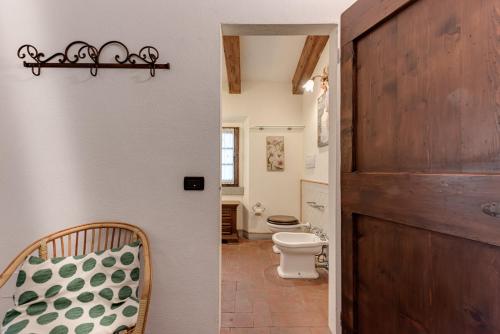 een badkamer met een toilet en een houten deur bij Il Pintello - Lo Scricciolo in Massanera