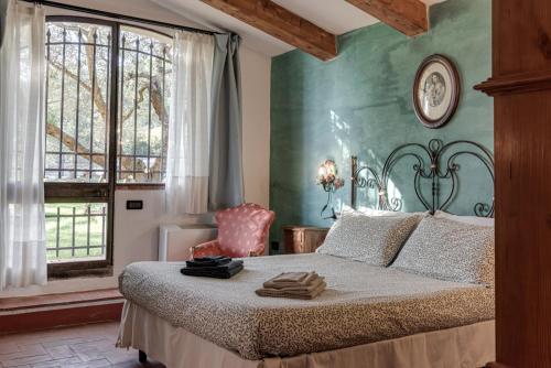 a bedroom with a large bed and a window at Il Pintello - Lo Scricciolo in Massanera