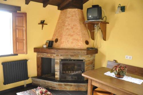 sala de estar con chimenea y TV en la parte superior en Casa rural "Matela", en Prado