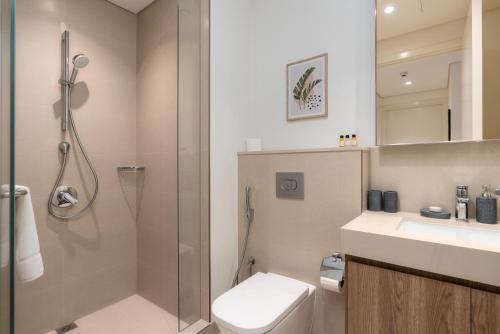 ein Bad mit einer Dusche, einem WC und einem Waschbecken in der Unterkunft White Sage - Base to Top of Burj Khalifa Views in this New 2BR in Dubai