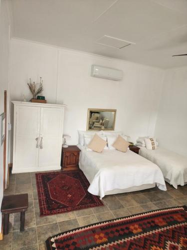 Dormitorio blanco con 2 camas y alfombra en Bridge View, en Hopetown
