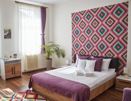 1 dormitorio con 1 cama grande y pared colorida en CONFORT HOUSE PLUS, en Alba Iulia