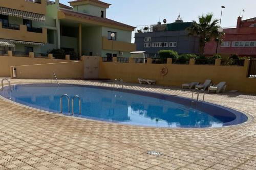 a swimming pool in the middle of a building at Duplex con piscina cerca del mar in Puertito de Güímar