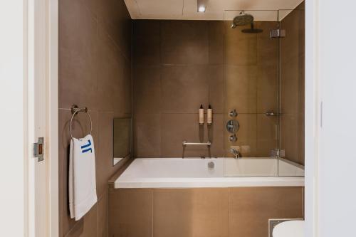 a bathroom with a bath tub and a sink at Hotel JL No76 in Amsterdam