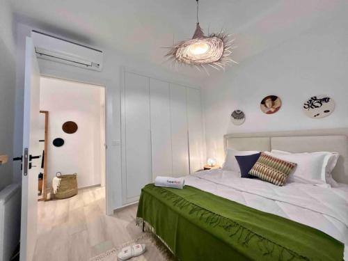 a bedroom with a large bed with a green bedspread at Le Bohémien in La Marsa